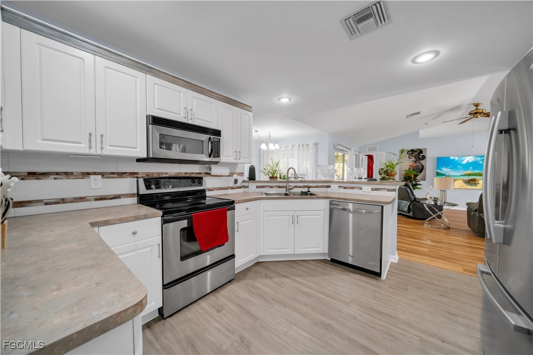 710 Homestead Road South Lehigh Acres, FL 33974 - Photo 24 of 38 a kitchen with a sink cabinets and wooden floor