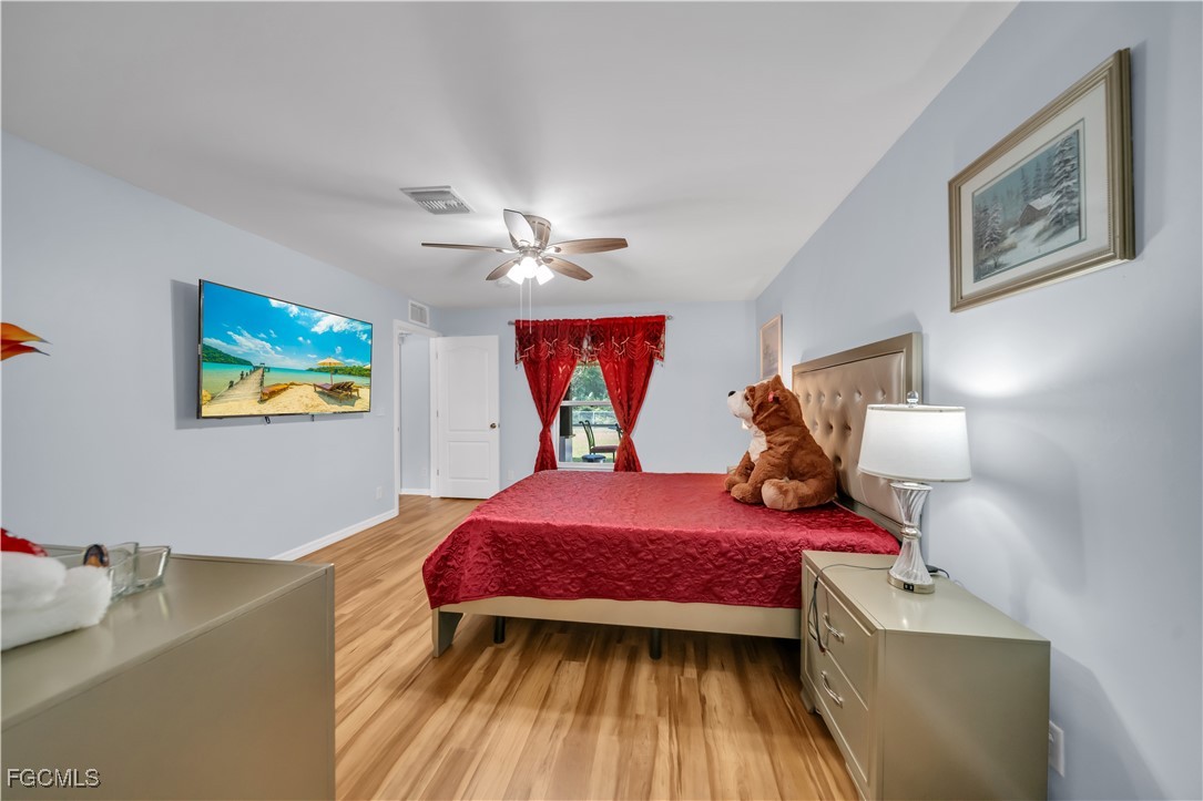 710 Homestead Road South Lehigh Acres, FL 33974 - Photo 30 of 38 a bedroom with a bed and a chandelier