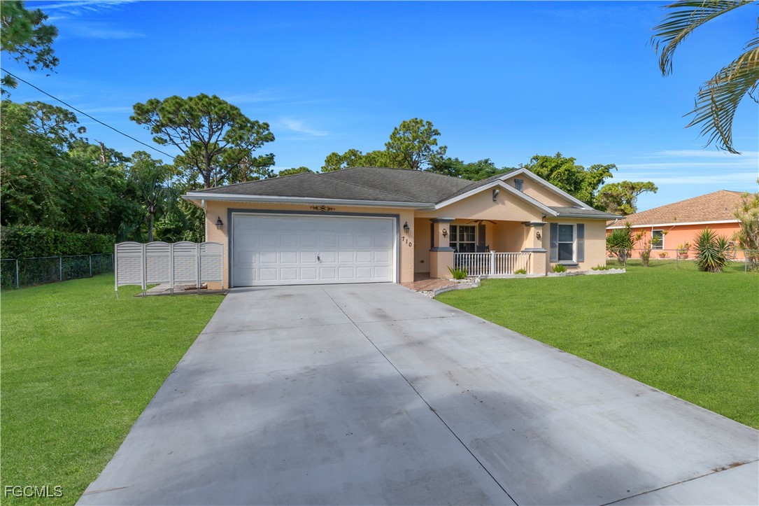 710 Homestead Road South Lehigh Acres, FL 33974 - Photo 33 of 38 a front view of a house with a yard and garage