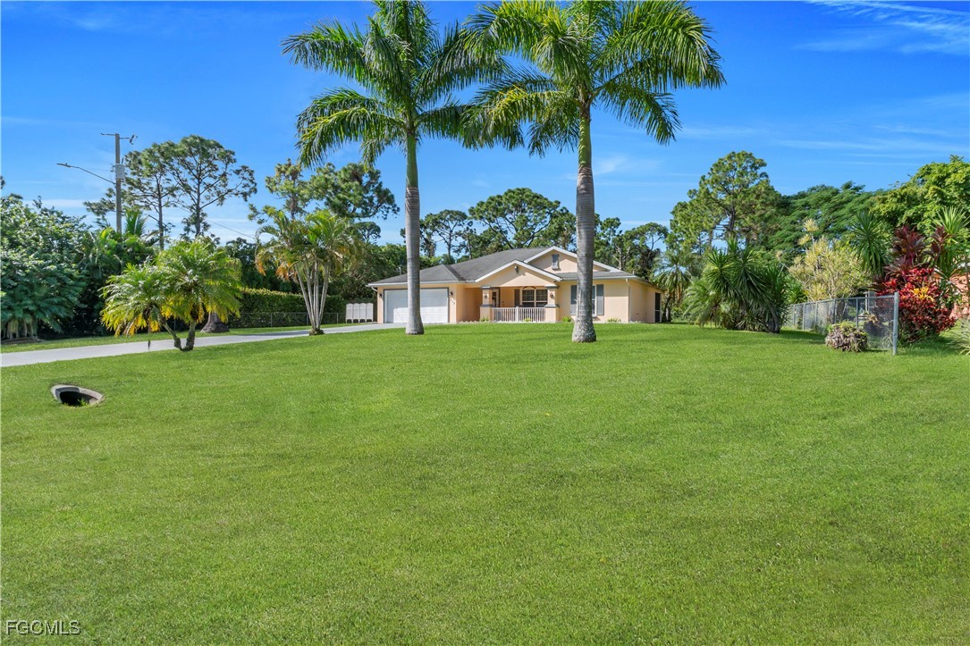 710 Homestead Road South Lehigh Acres, FL 33974 - Photo 35 of 38 a view of a house with a yard and palm trees