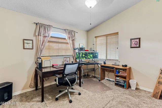 a view of a workspace with furniture and a window