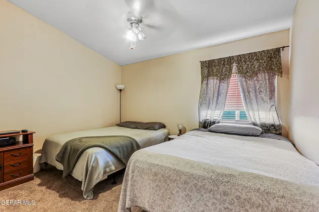 a bedroom with two beds and a chandelier