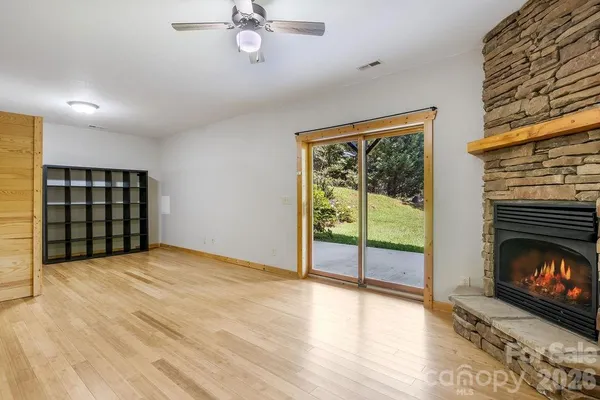 a view of an empty room with a fireplace and a window
