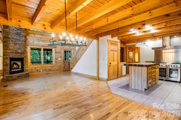 a view of a hall with wooden floor and a fireplace