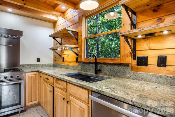 a kitchen with sink a window and stainless steel appliances
