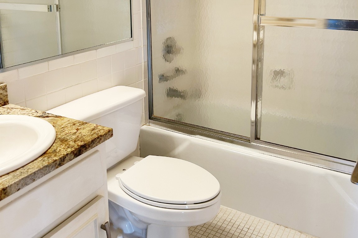 1122 Colorado Street, Unit 1101 Austin, TX 78701 - Photo 5 of 17 a bathroom with a granite countertop toilet and a sink