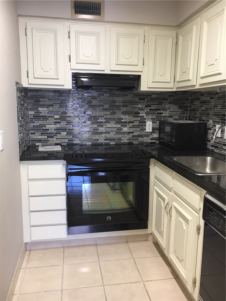 1122 Colorado Street, Unit 1101 Austin, TX 78701 - Photo 8 of 17 a kitchen with granite countertop white cabinets and stainless steel appliances