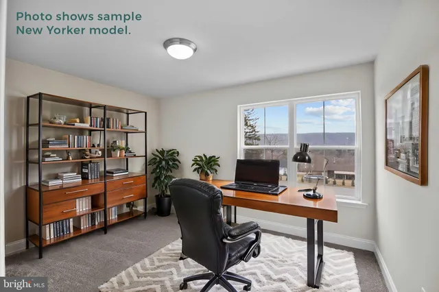 a view of a workspace with furniture and a window