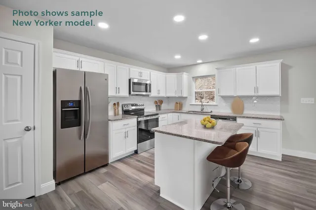 a kitchen with a refrigerator a stove a sink and a dining table with wooden floor