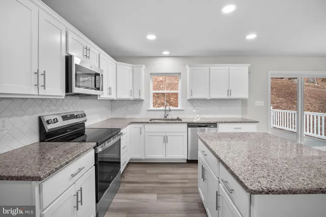 a kitchen with stainless steel appliances granite countertop a stove a sink and a granite counter tops