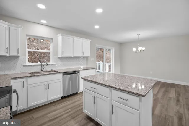 a kitchen with granite countertop white cabinets and white appliances