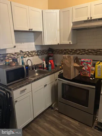 a view of a kitchen with wooden floor and electronic appliances