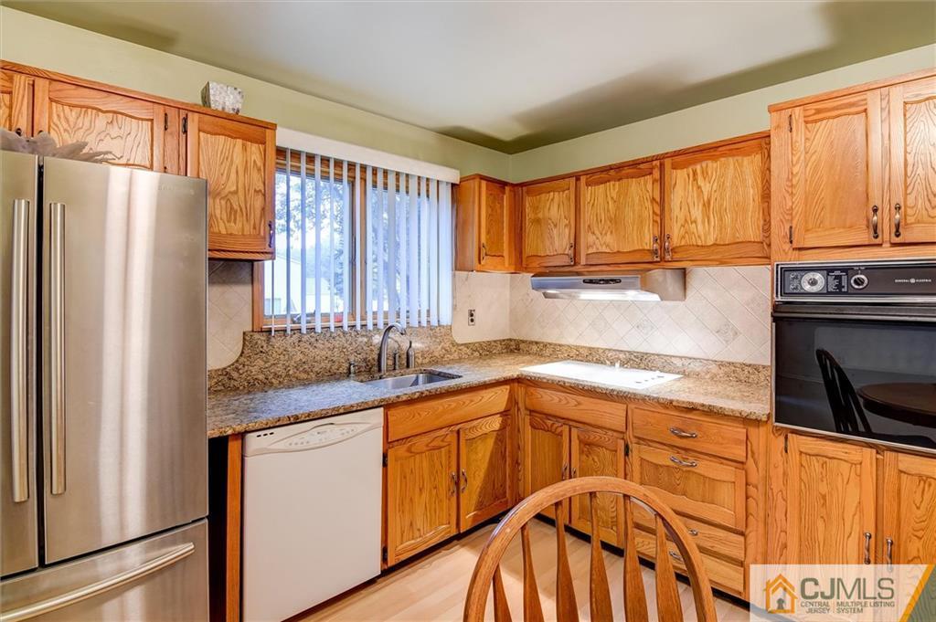 7 Arden Road Old Bridge, NJ 08857 - Photo 4 of 18 a kitchen with stainless steel appliances granite countertop a refrigerator a sink dishwasher and wooden cabinets with wooden floor