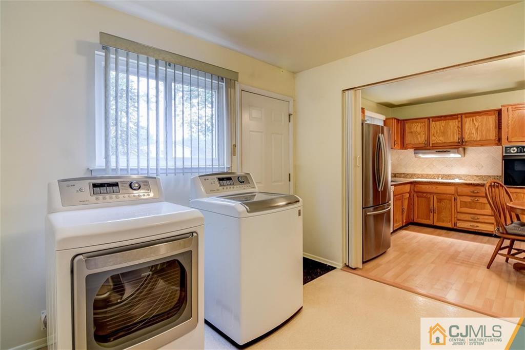 7 Arden Road Old Bridge, NJ 08857 - Photo 9 of 18 a view of washer and dryer with kitchen in the background
