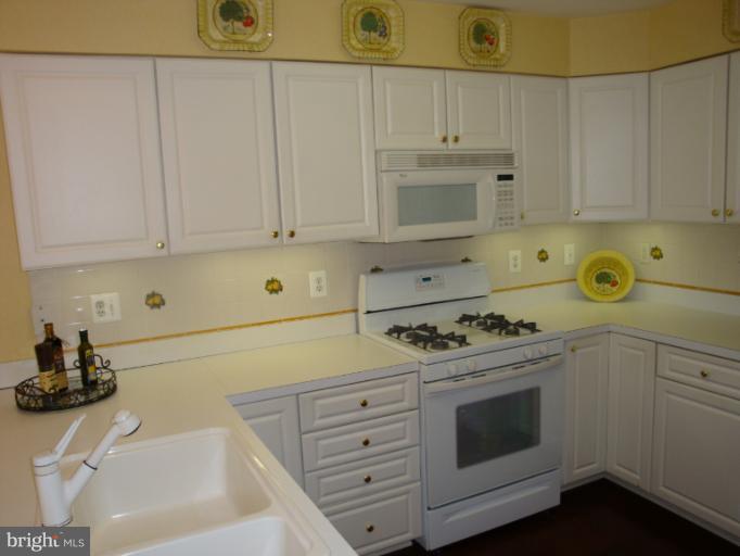12021 Tralee Road, Unit 201 Lutherville-Timonium, MD 21093 - Photo 8 of 30 a kitchen with white cabinets and appliances