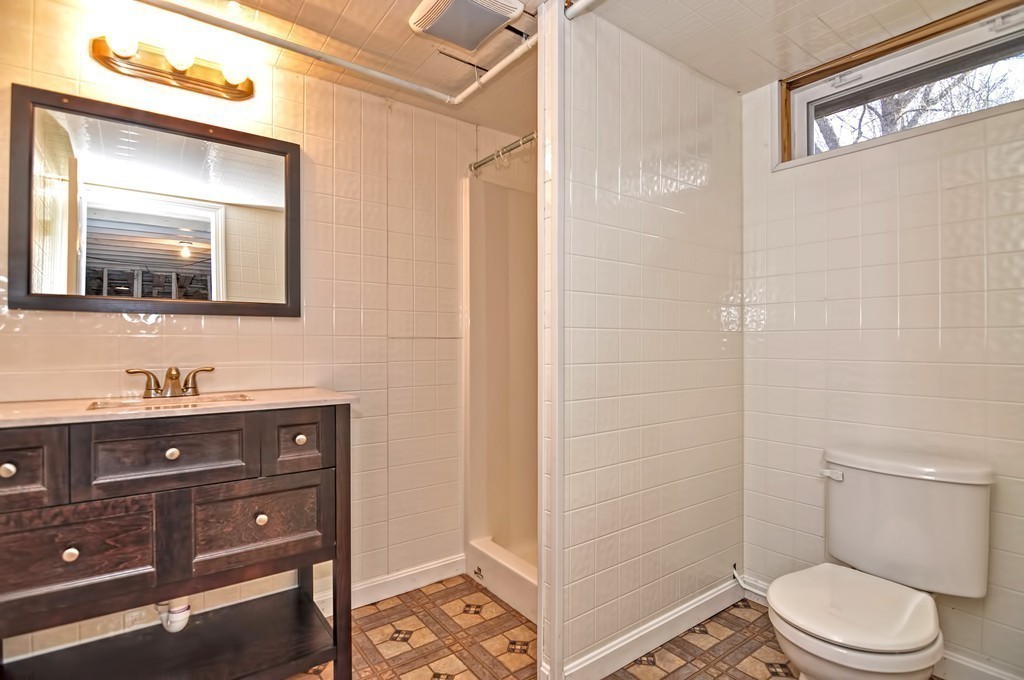 66 Old Post Road Walpole, MA 02032 - Photo 26 of 30 a bathroom with a toilet a sink a mirror a vanity and shower