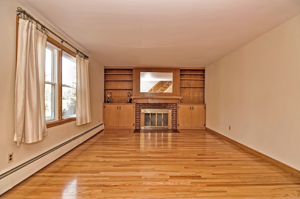 66 Old Post Road Walpole, MA 02032 - Photo 10 of 30 a view of a livingroom with wooden floor and a fireplace