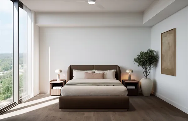 a bedroom with a large bed and a potted plant