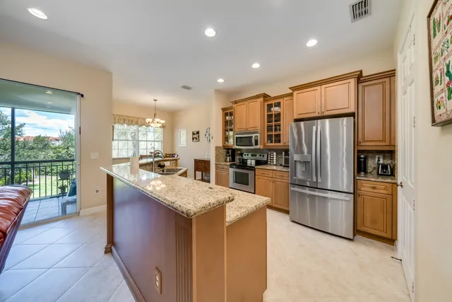 a kitchen with stainless steel appliances granite countertop a refrigerator and a sink
