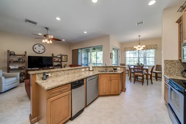 a kitchen with a large counter top space appliances and living room view