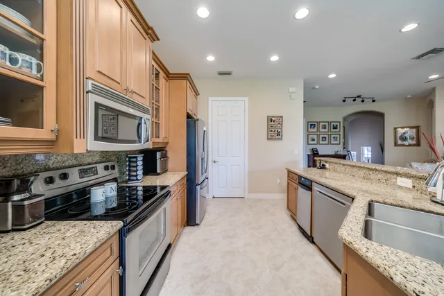 a large kitchen with stainless steel appliances granite countertop a stove and a sink