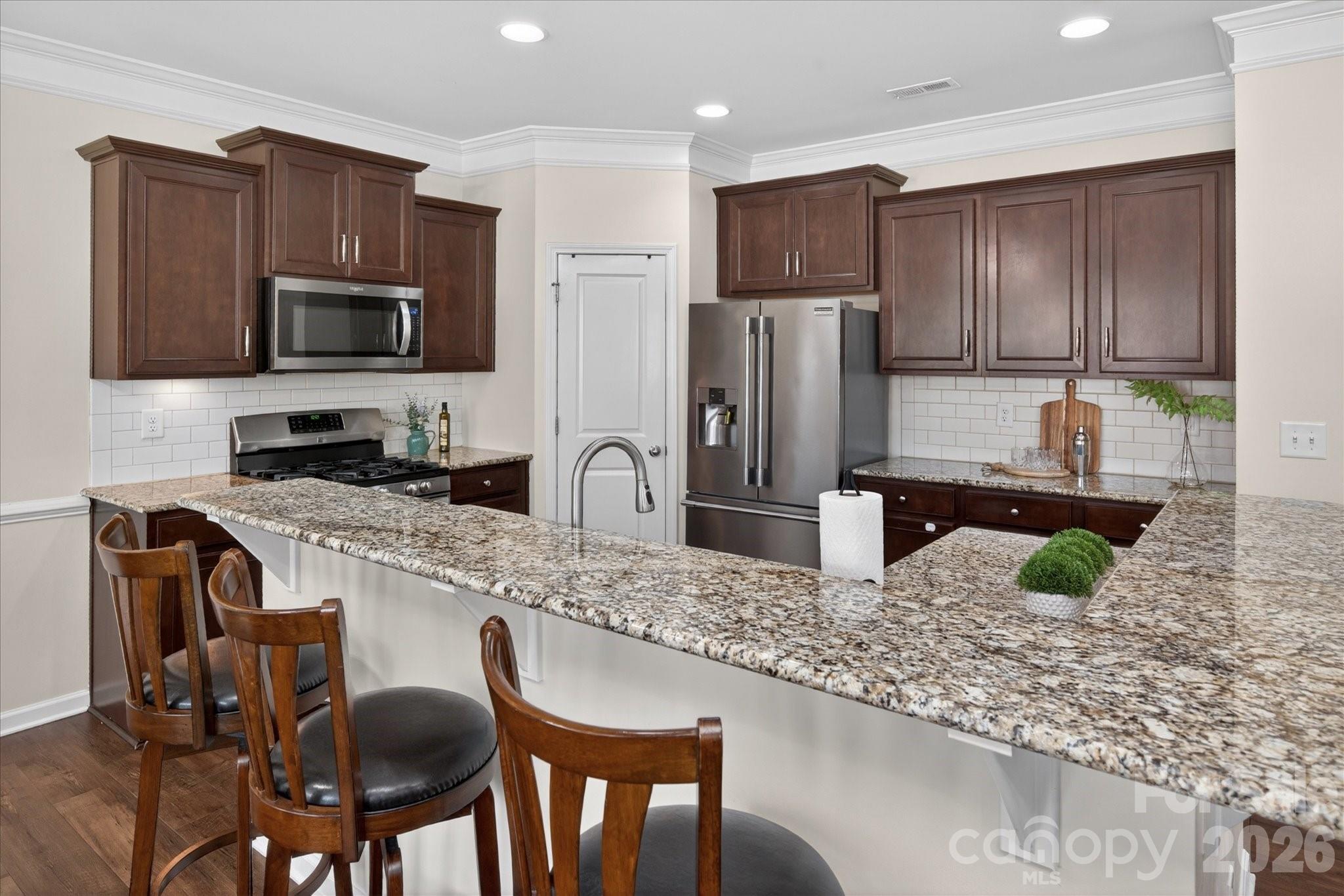 2032 Pinyon Lane Lancaster, SC 29720 - Photo 16 of 44 a kitchen with granite countertop wooden cabinets a refrigerator a stove a sink and a granite counter tops