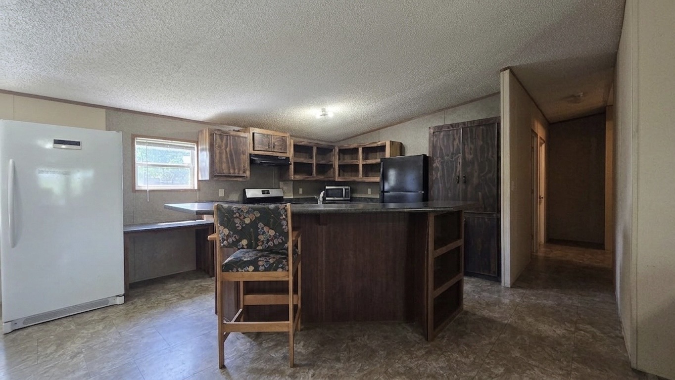 305 Thompson Road Dale, TX 78616 - Photo 4 of 11 A spacious kitchen features a large central island and dark wood cabinetry.