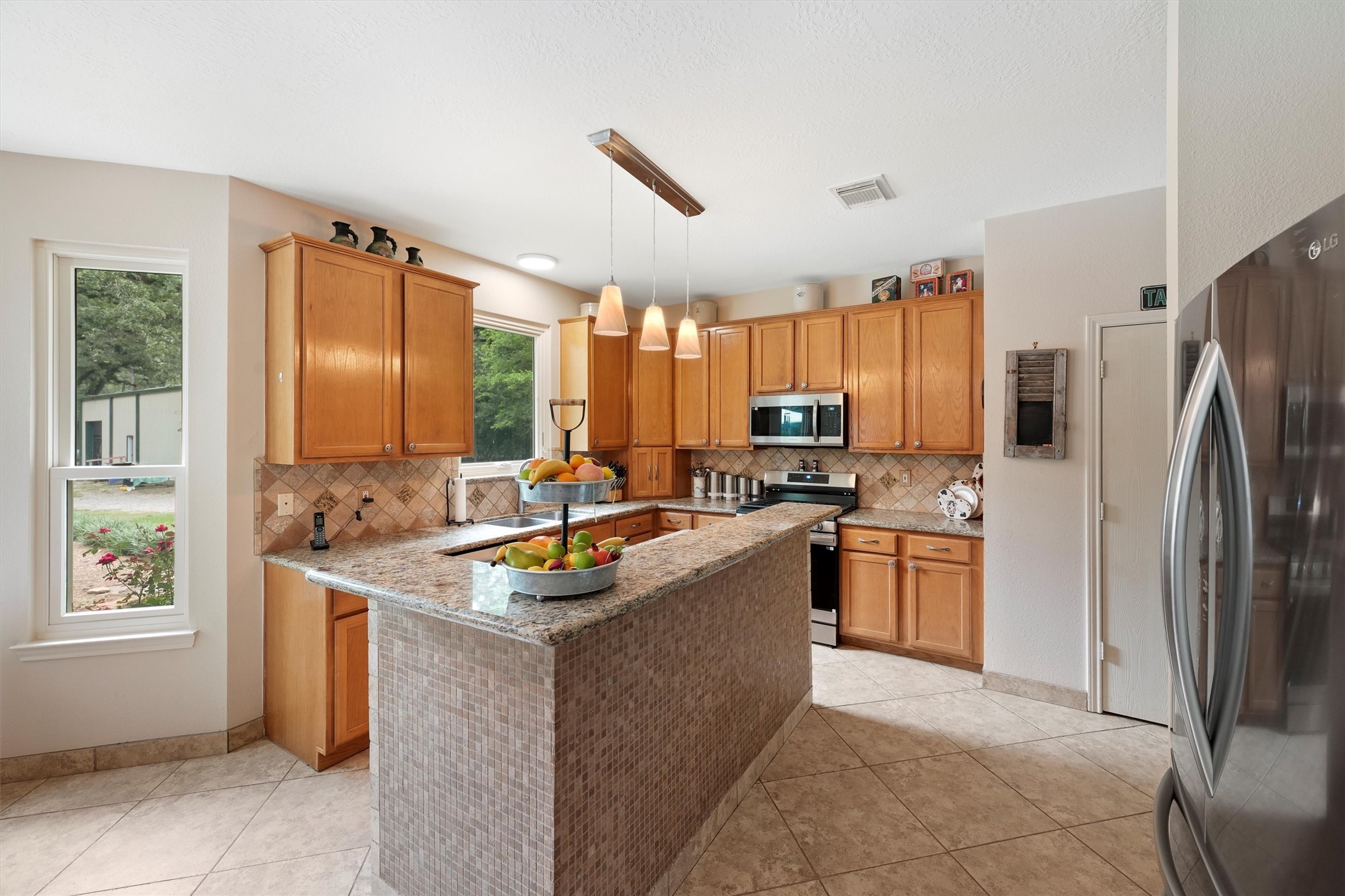 6803 Treaschwig Road Spring, TX 77373 - Photo 9 of 22 a kitchen with stainless steel appliances granite countertop a refrigerator a sink a stove and island