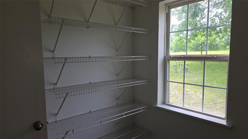 2474 Joe Davis Road Whitewright, TX 75491 - Photo 11 of 12 Pantry featuring wire shelving for organized storage and a multi-pane window providing natural light