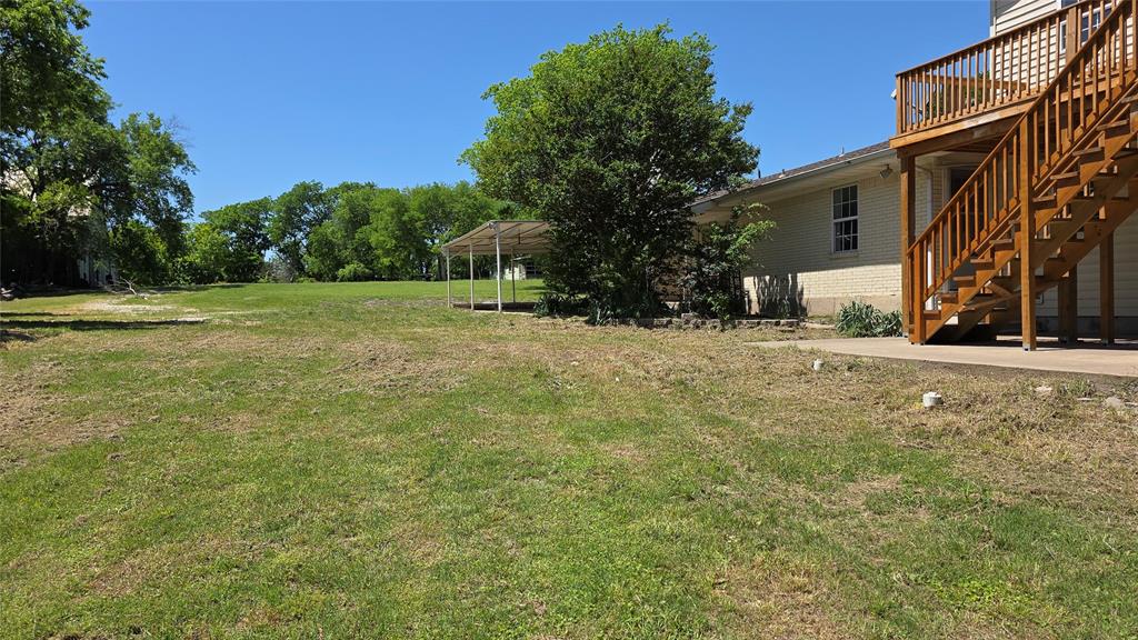 2474 Joe Davis Road Whitewright, TX 75491 - Photo 3 of 12 Expansive grassy yard with mature trees and a covered patio structure