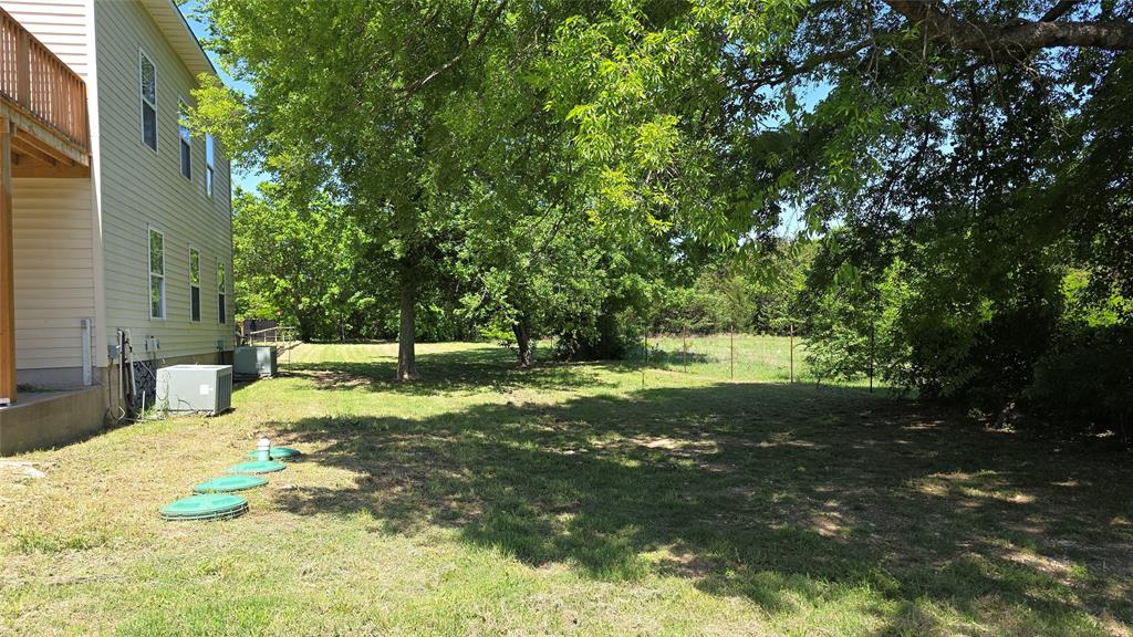 2474 Joe Davis Road Whitewright, TX 75491 - Photo 4 of 12 Expansive green space featuring mature trees and a partial wire fence
