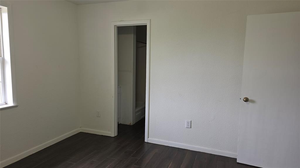 2474 Joe Davis Road Whitewright, TX 75491 - Photo 8 of 12 Room featuring dark wood-finish flooring, white painted walls, and white baseboards