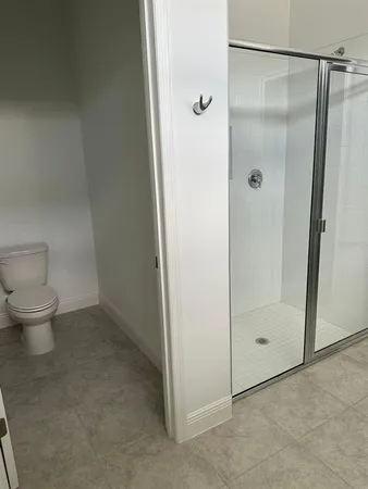 a bathroom with a granite countertop shower and a toilet