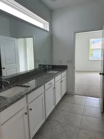 a bathroom with a granite countertop sink and a mirror