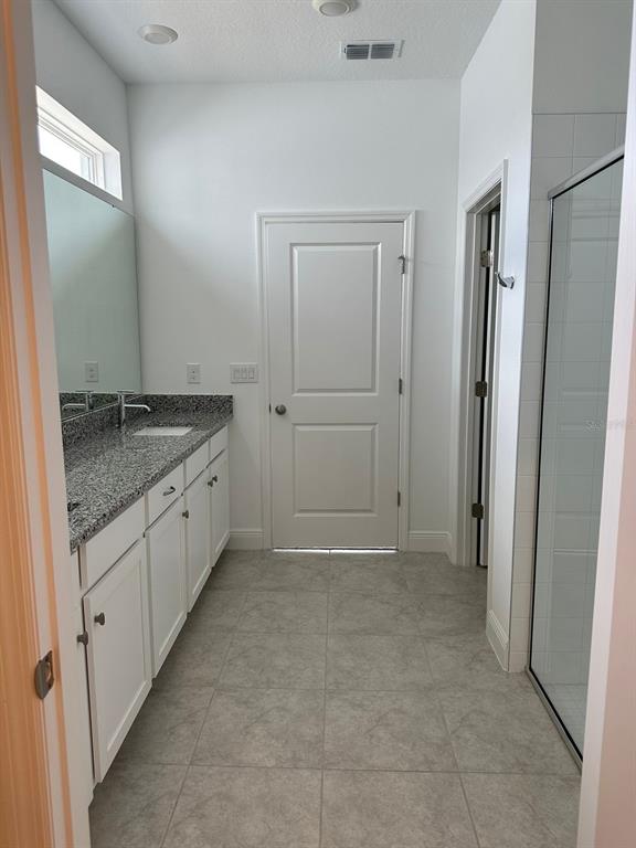 19044 Blueleaf Street Orlando, FL 32827 - Photo 31 of 42 a bathroom with a granite countertop sink and a mirror