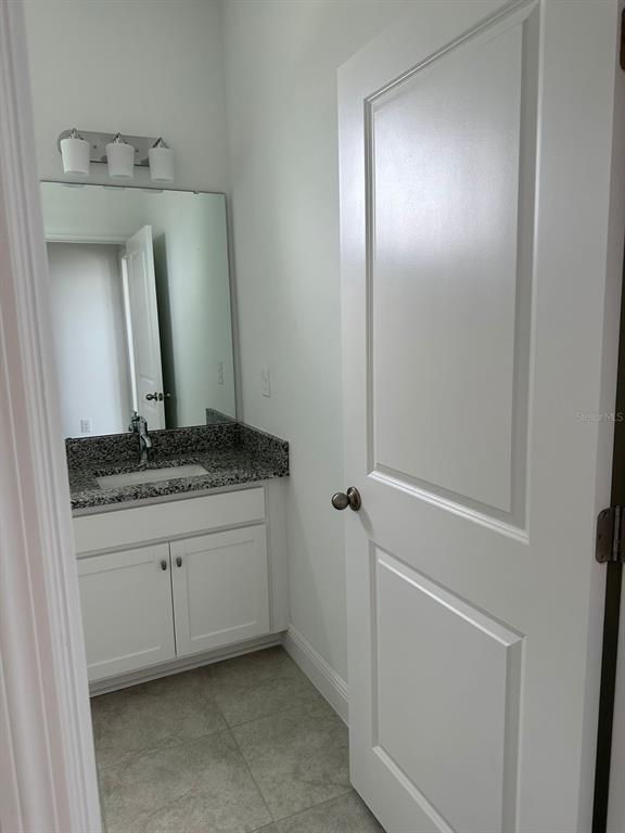 19044 Blueleaf Street Orlando, FL 32827 - Photo 38 of 42 a bathroom with a granite countertop sink and a mirror