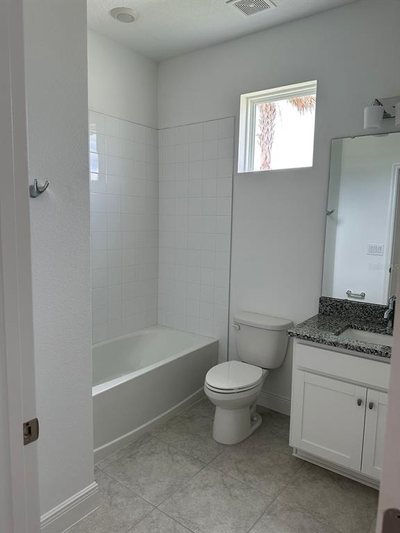 19044 Blueleaf Street Orlando, FL 32827 - Photo 39 of 42 a bathroom with a granite countertop sink a toilet and bathtub