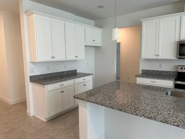 a kitchen with granite countertop cabinets and refrigerator