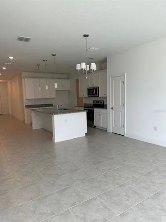 a kitchen with a sink and dishwasher a kitchen island with wooden floor