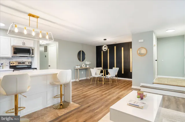 a living room with furniture a chandelier and a flat screen tv
