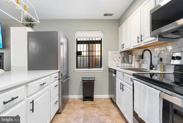 a kitchen with white cabinets and appliances