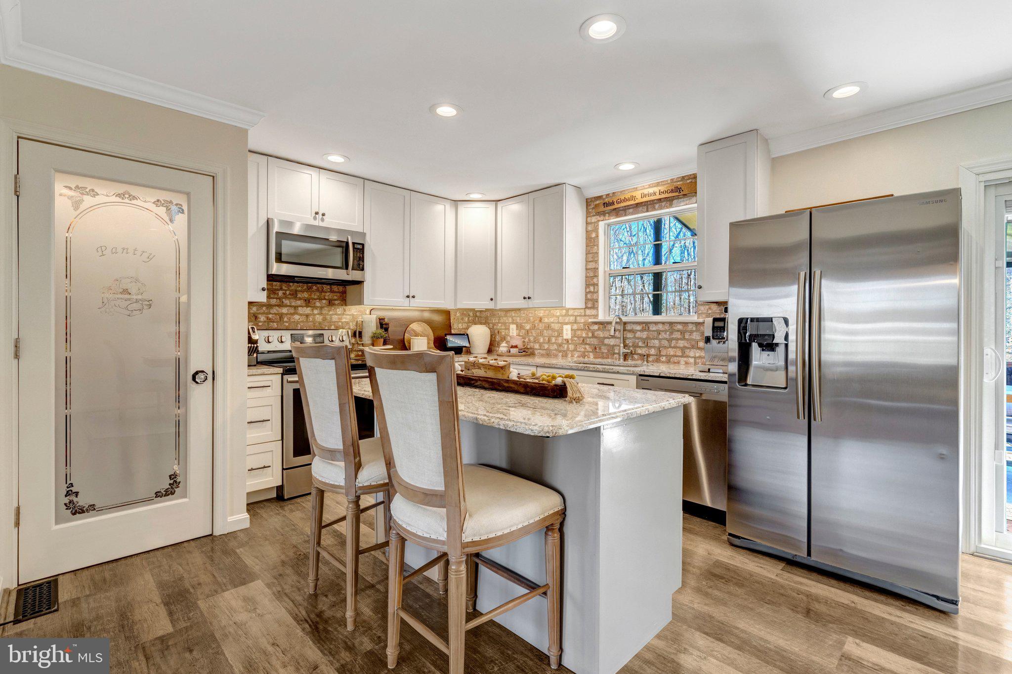 8585 Short Street Manassas, VA 20112 - Photo 12 of 31 a kitchen with white cabinets and stainless steel appliances