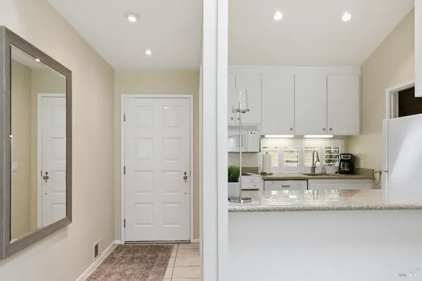 a kitchen with granite countertop white cabinets and stainless steel appliances