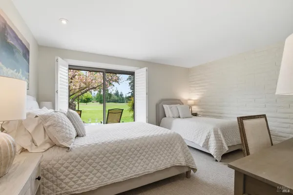 a bedroom with two beds and a large window