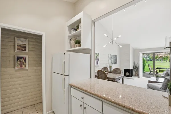a living room with furniture a large window and stainless steel appliances