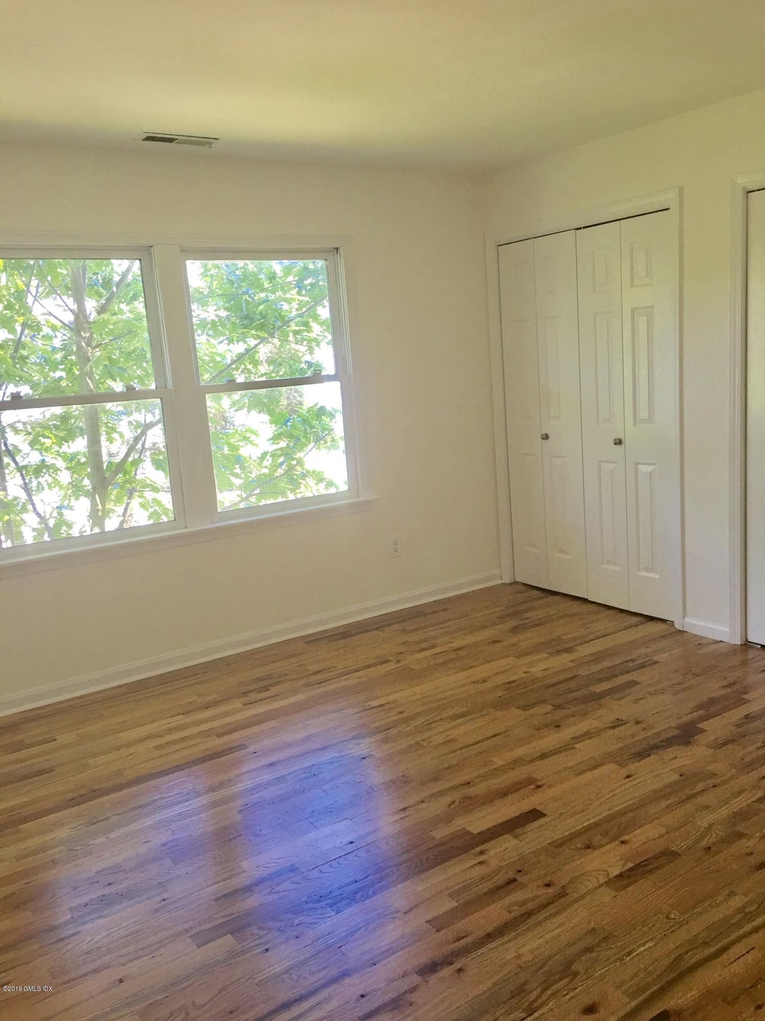 16 Ritch Avenue, Unit B Greenwich, CT 06830 - Photo 8 of 12 a view of an empty room with wooden floor and a window