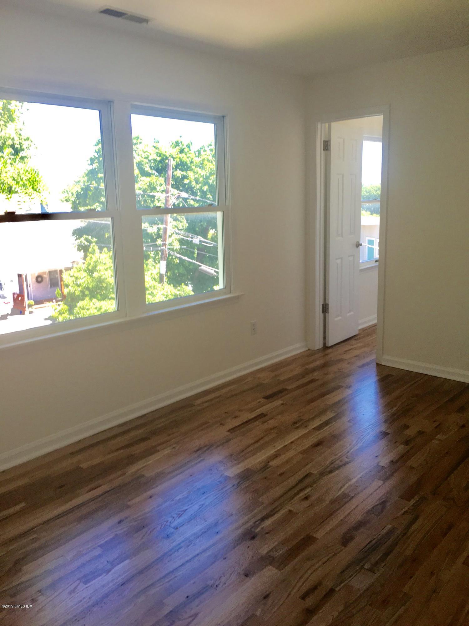 16 Ritch Avenue, Unit B Greenwich, CT 06830 - Photo 10 of 12 a view of an empty room with wooden floor and a window