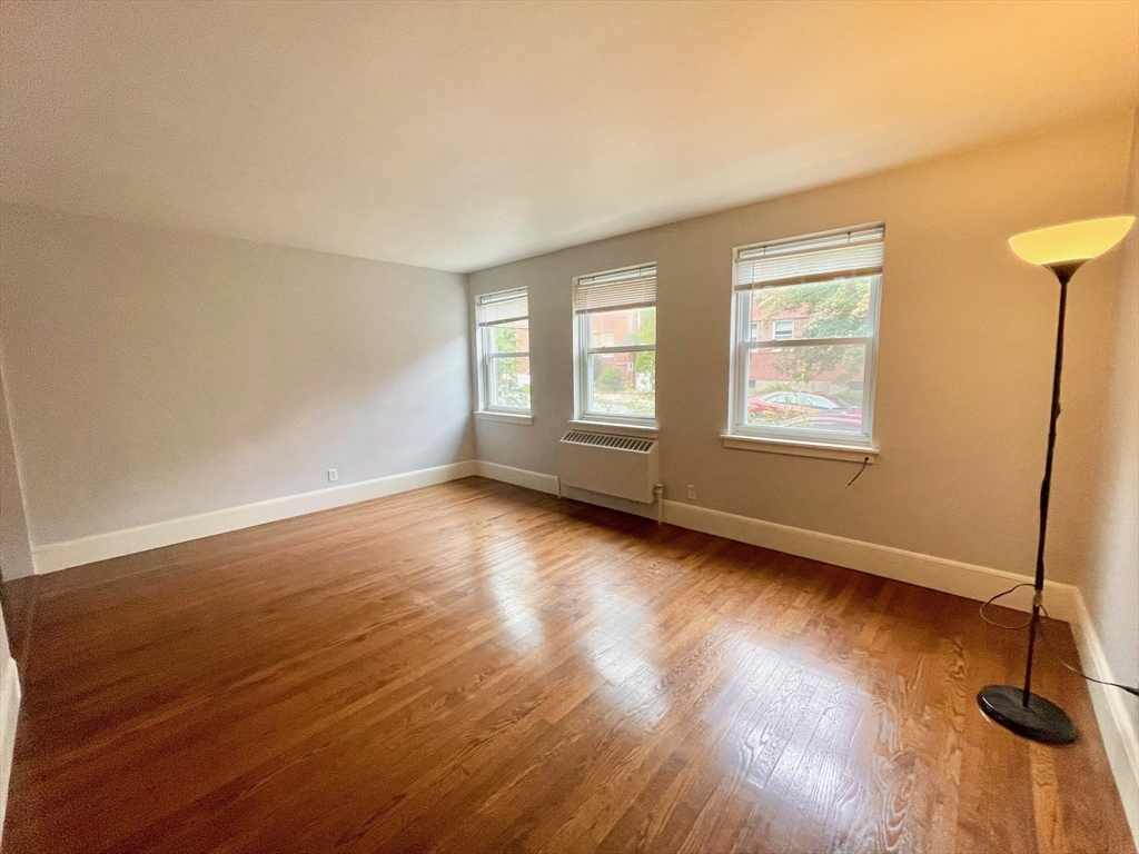 1 O'Leary Way, Unit 91 Boston, MA 02130 - Photo 2 of 12 an empty room with wooden floor and windows