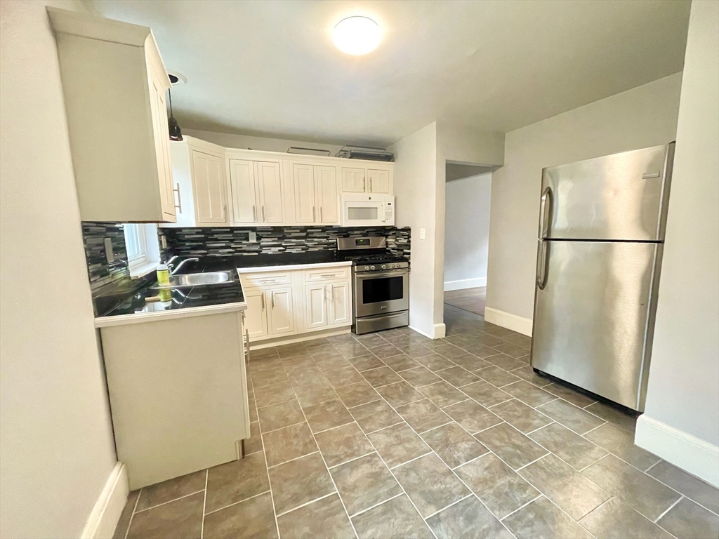 1 O'Leary Way, Unit 91 Boston, MA 02130 - Photo 4 of 12 a kitchen with a stove a refrigerator and a sink