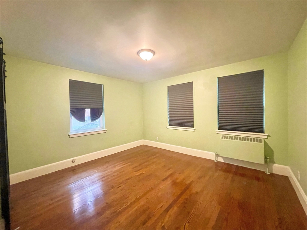 1 O'Leary Way, Unit 91 Boston, MA 02130 - Photo 7 of 12 a view of an empty room with wooden floor and a window